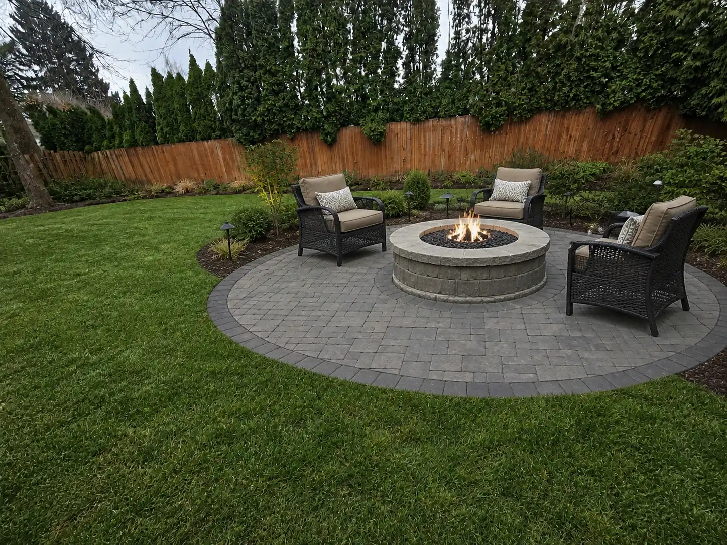 Same fenced backyard after pool removal, with lawn, patio, seating and fire pit
